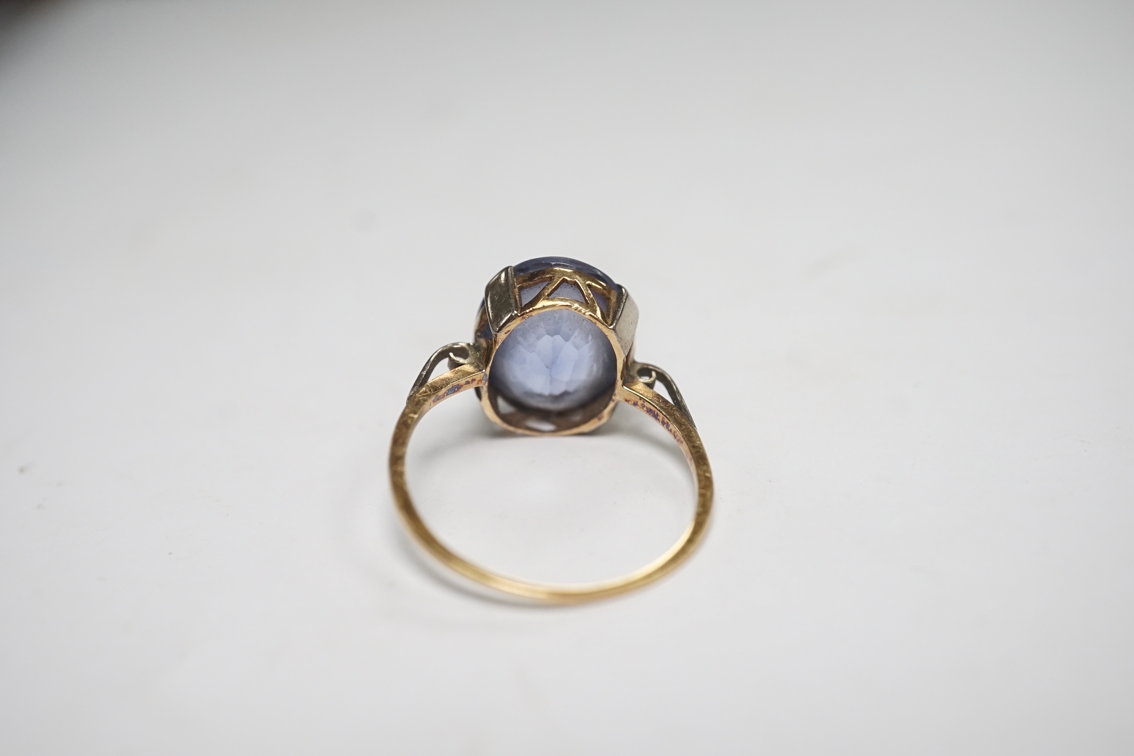 A yellow metal and single stone oval cut synthetic? sapphire set ring, size N, gross weight 2.8 grams. Condition - poor to fair